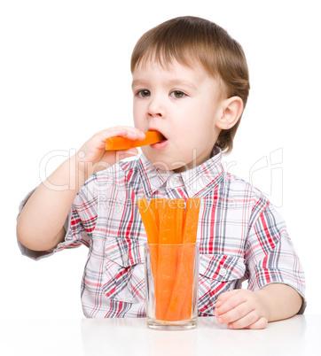 Little boy is eating carrot