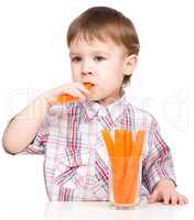 Little boy is eating carrot