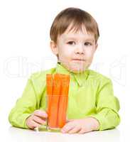 Little boy is eating carrot