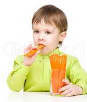 Little boy is eating carrot