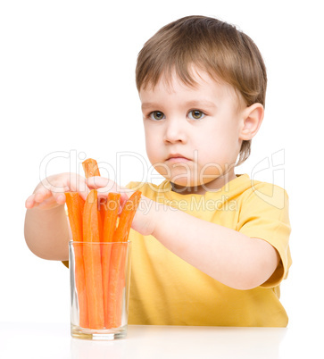 Little boy is eating carrot