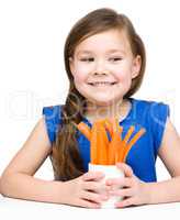 Cute little girl is eating carrot