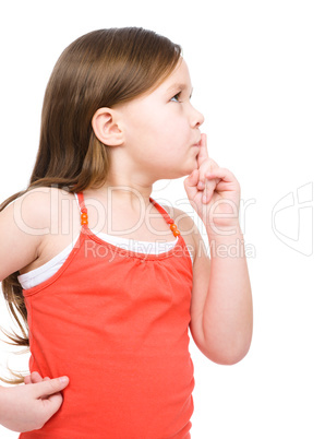 Little girl is showing hush gesture