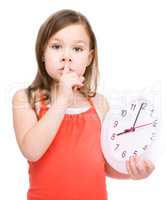 Little girl is holding big clock