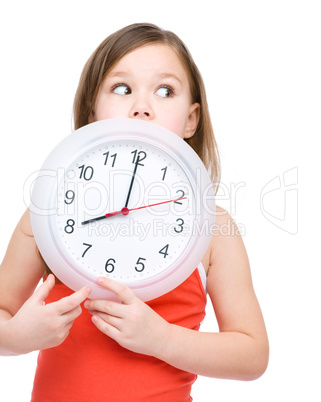 Little girl is holding big clock