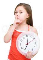 Little girl is holding big clock