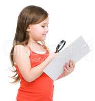 Girl is looking at big paper using magnifier