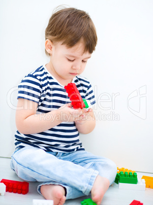 Boy is playing with building blocks