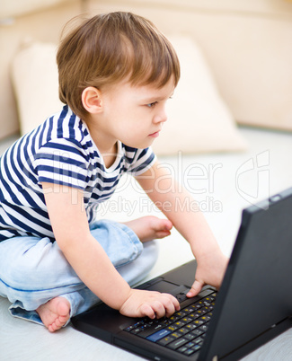 Little boy is playing on laptop