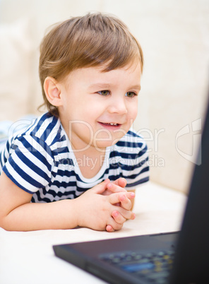 Little boy is playing on laptop