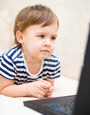 Little boy is playing on laptop