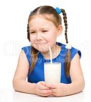 Sad little girl with a glass of milk