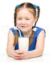 Sad little girl with a glass of milk