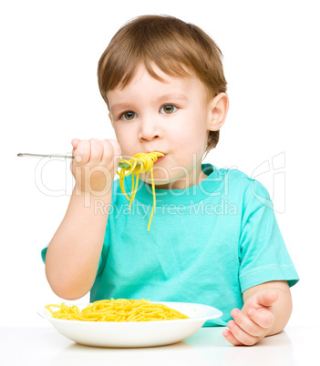 Little boy is eating spaghetti