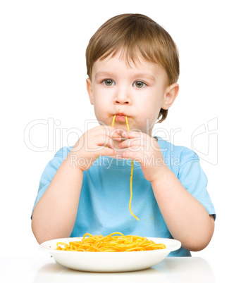 Little boy is eating spaghetti