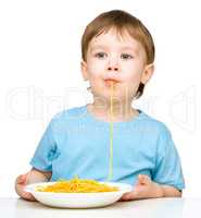 Little boy is eating spaghetti