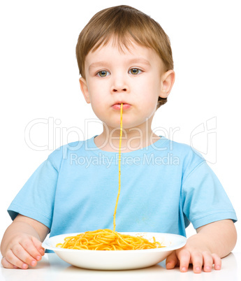 Little boy is eating spaghetti