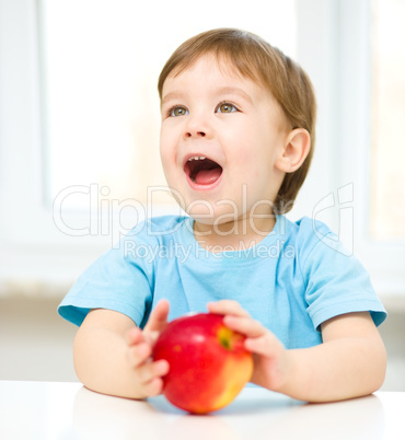 Portrait of a happy little boy with apple