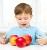 Portrait of a happy little boy with apples