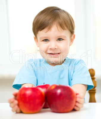 Portrait of a happy little boy with apples