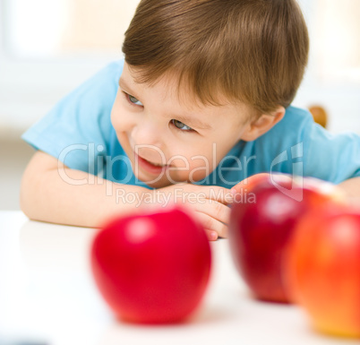 Portrait of a happy little boy with apples