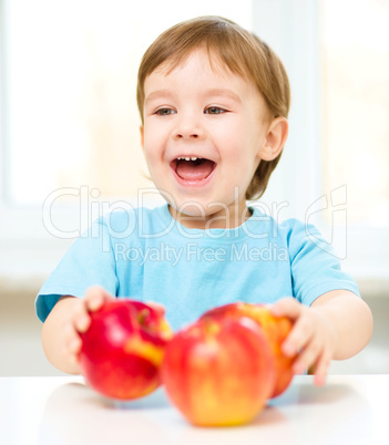 Portrait of a happy little boy with apples