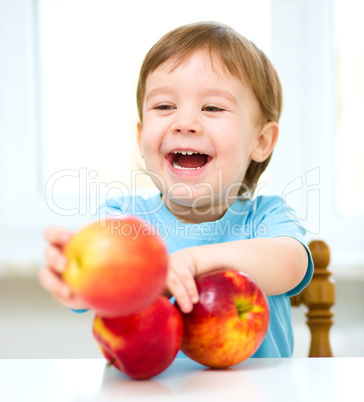 Portrait of a happy little boy with apples