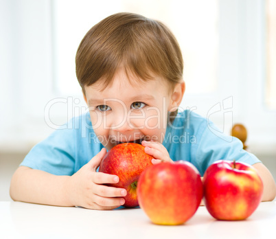 Portrait of a happy little boy with apples