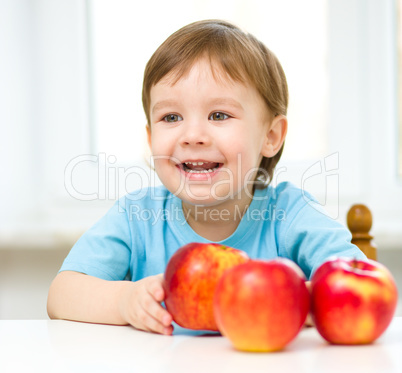 Portrait of a happy little boy with apples