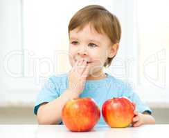 Portrait of a happy little boy with apples