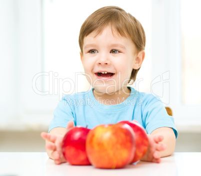 Portrait of a happy little boy with apples