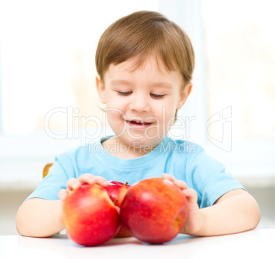 Portrait of a happy little boy with apples