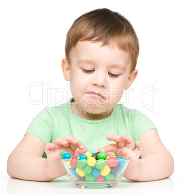 Portrait of a sad little boy with candies