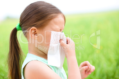 Little girl is blowing her nose