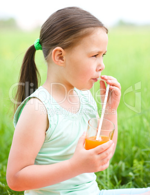 Little girl is drinking orange juice