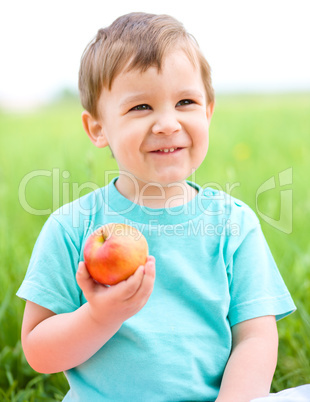 Portrait of a happy little boy with apple