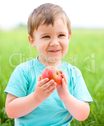 Portrait of a happy little boy with apple
