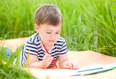 Little boy is playing with pencils