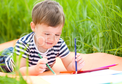 Little boy is playing with pencils