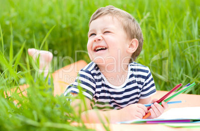 Little boy is playing with pencils