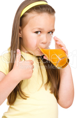 Little girl is drinking orange juice