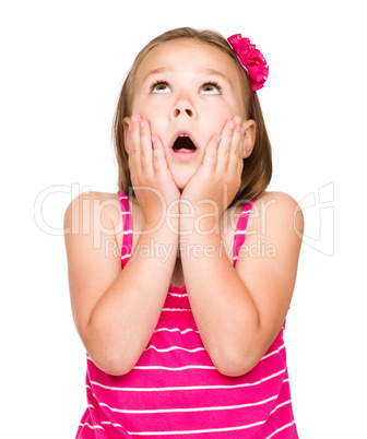 Little girl is holding her face in astonishment