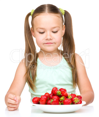 Little girl is eating strawberries