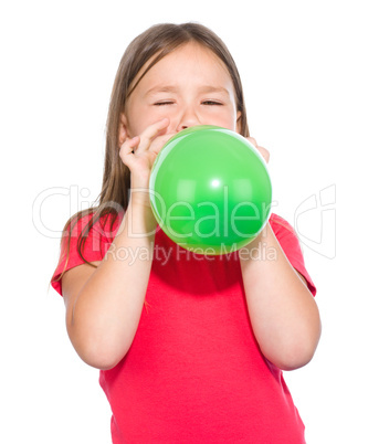 Little girl is inflating green balloon