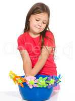Little girl is playing with flowers