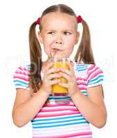 Little girl unwillingly drinking orange juice