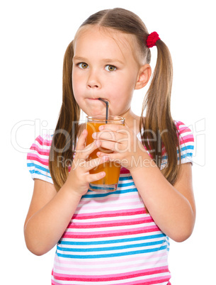 Little girl is drinking carrot juice