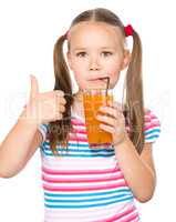 Little girl is drinking carrot juice