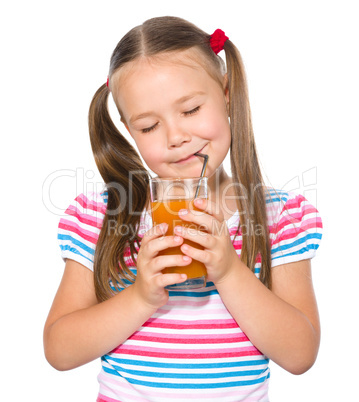 Little girl is drinking carrot juice