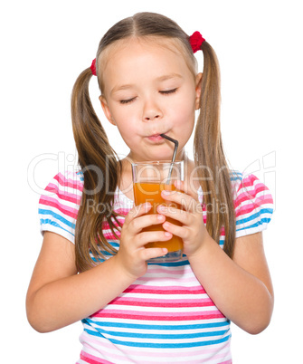 Little girl is drinking carrot juice